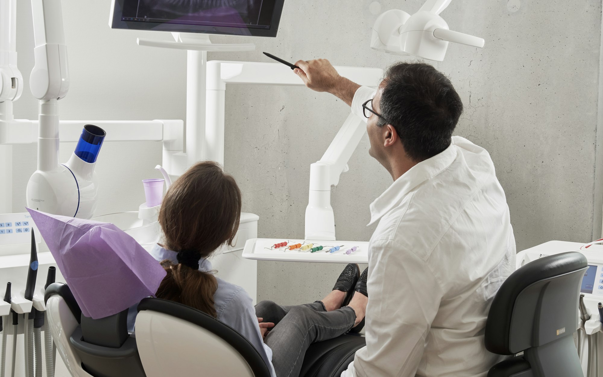 A dentist walking a young patient through her scan