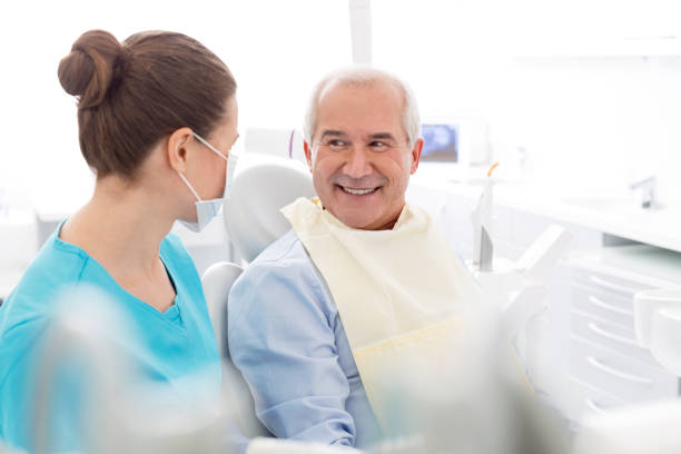 A smiling patient talking with a dental hygienist in the chair